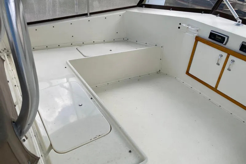 Golden Olive Yacht Photos Pics 1985 Hatteras Sportfish boat interior with white seating and storage compartments.