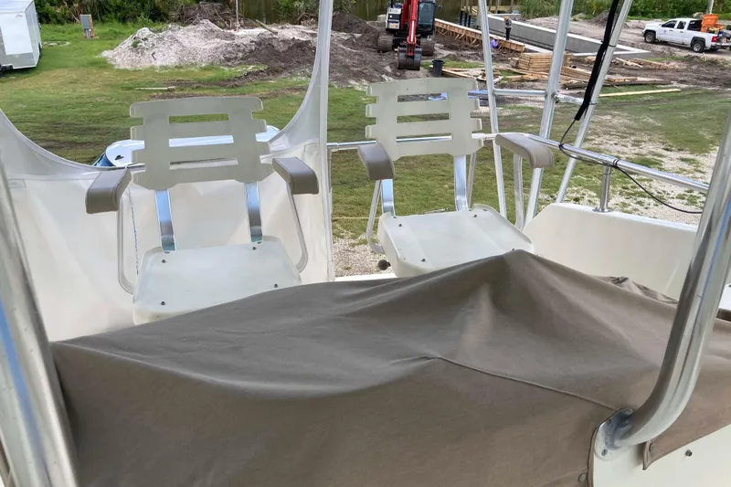 Golden Olive Yacht Photos Pics 1985 Hatteras Sportfish boat with white captain chairs and covered console.
