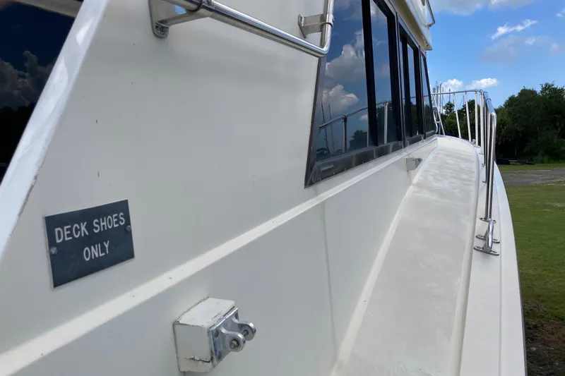 Golden Olive Yacht Photos Pics 1985 Hatteras Sportfish yacht with "Deck Shoes Only" sign, side view.