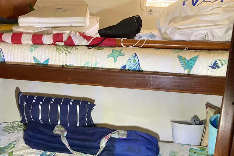 Golden Olive Yacht Photos Pics Interior of 1985 Hatteras Sportfish boat with nautical-themed bedding and storage.