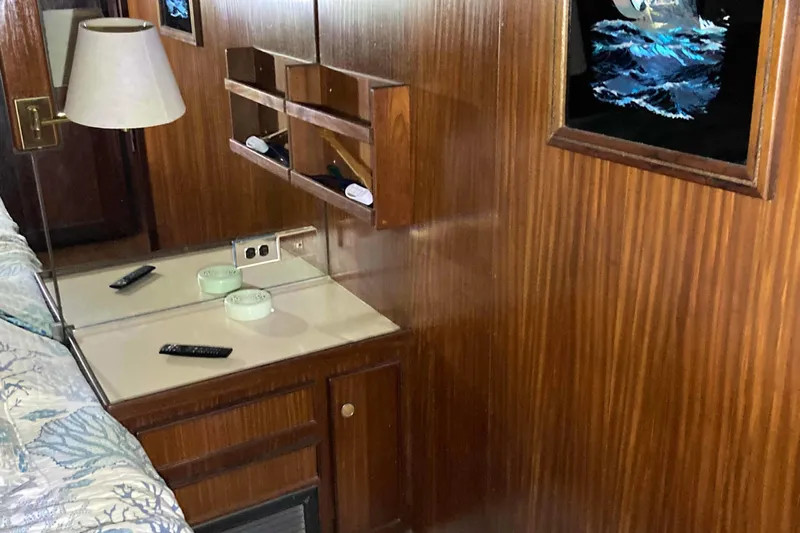 Golden Olive Yacht Photos Pics 1985 Hatteras Sportfish interior with wood paneling, desk, and wall art.