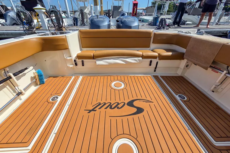 Yacht Photos Pics 2008 Scout 295 Abaco boat interior with teak flooring and cushioned seating at a marina.