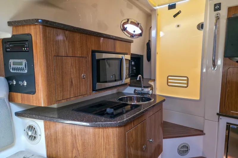  Yacht Photos Pics 2008 Scout 295 Abaco boat interior with kitchenette, featuring wood cabinetry and modern appliances.