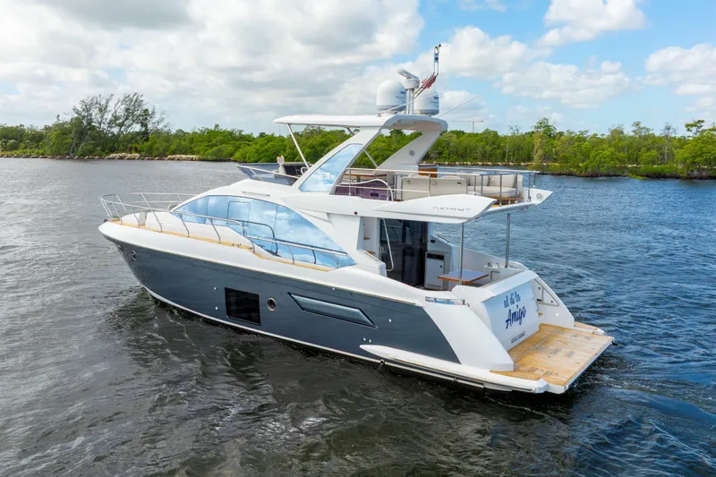 Our Trade Yacht Photos Pics 2018 Azimut 50 Fly yacht cruising on a scenic waterway under a partly cloudy sky.