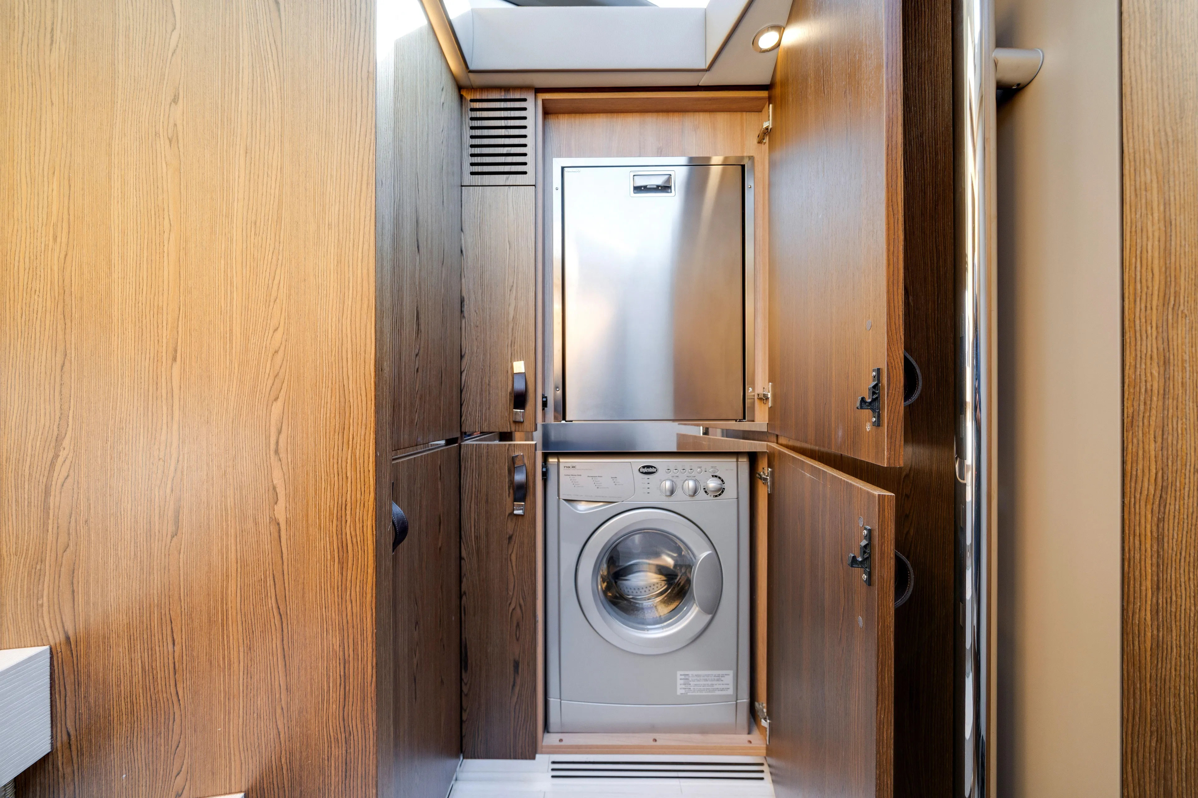 Our Trade Yacht Photos Pics Laundry area in 2018 Azimut 50 Fly yacht with wood paneling and washing machine.