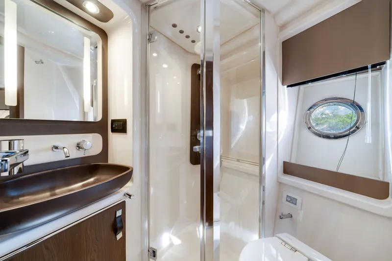 Our Trade Yacht Photos Pics Luxurious bathroom interior of 2018 Azimut 50 Fly yacht with modern fixtures and porthole window.