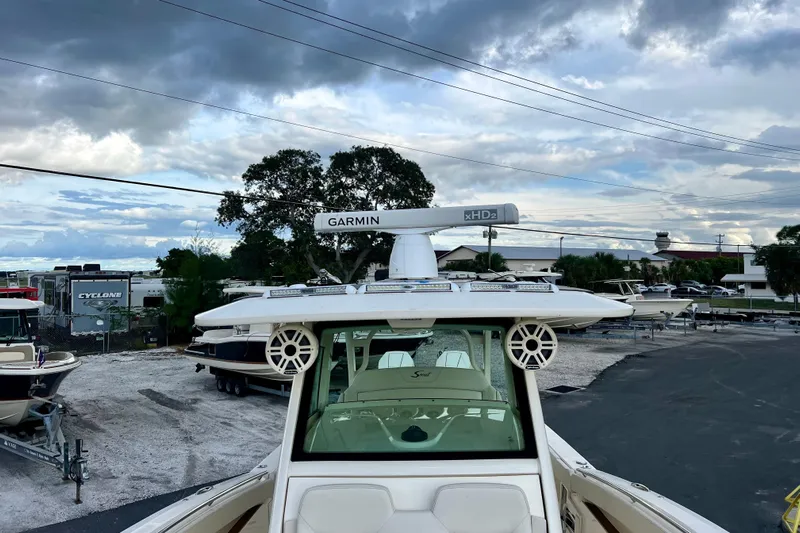  Yacht Photos Pics 2023 Scout 330 LXF boat with Garmin radar, parked outdoors under cloudy sky.