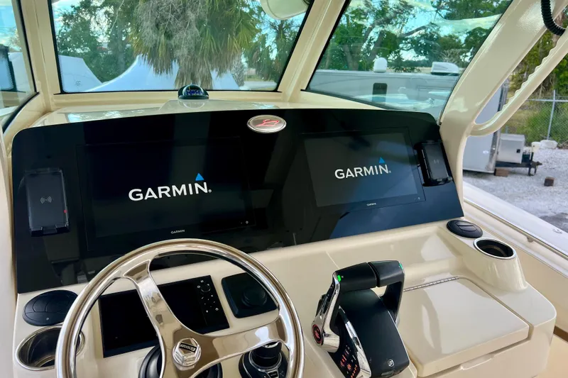  Yacht Photos Pics 2023 Scout 330 LXF boat dashboard with Garmin navigation displays and steering wheel.
