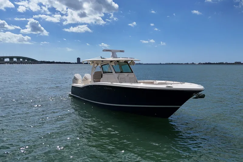  Yacht Photos Pics 2023 Scout 330 LXF boat on calm water under a clear blue sky.