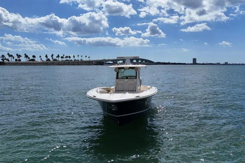  Yacht Photos Pics 2023 Scout 330 LXF boat on calm water under a partly cloudy sky.