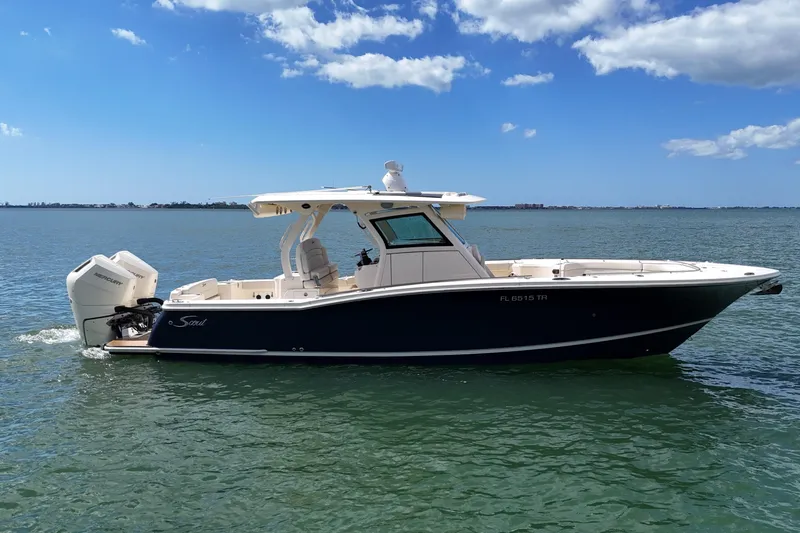  Yacht Photos Pics 2023 Scout 330 LXF boat on calm water under a blue sky.