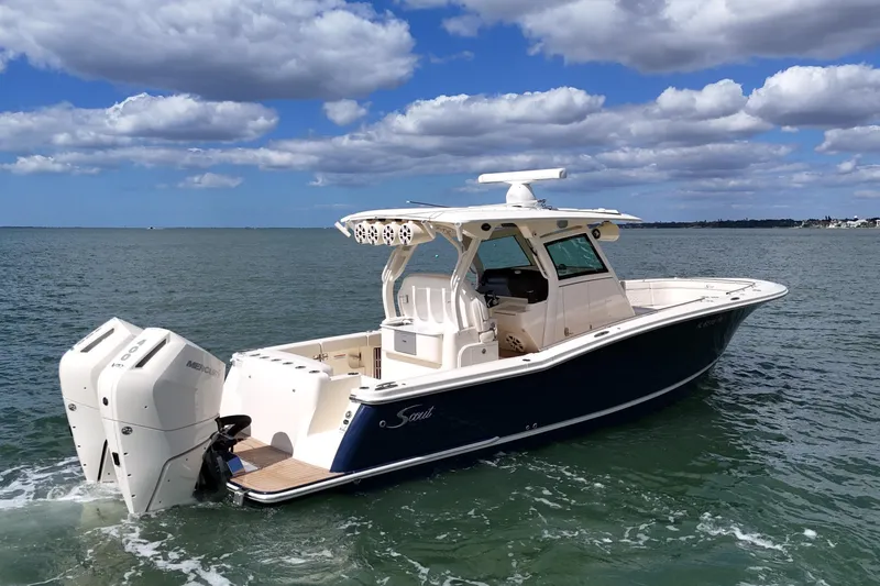  Yacht Photos Pics 2023 Scout 330 LXF boat on water under blue sky with clouds.