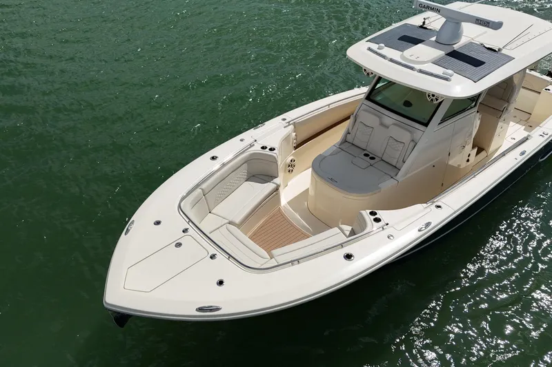  Yacht Photos Pics 2023 Scout 330 LXF boat on water, showcasing sleek design and spacious seating.