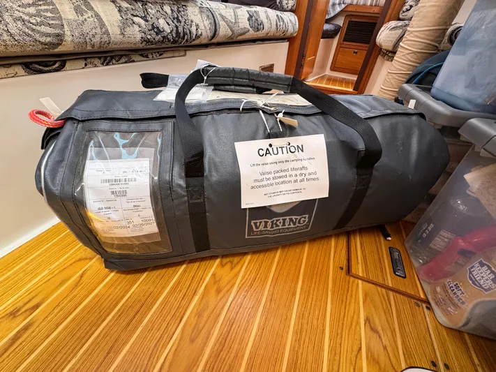 Shenanigans Yacht Photos Pics Viking life-saving equipment bag on Catalina 400 MkII yacht, 2001 model, placed on wooden floor.