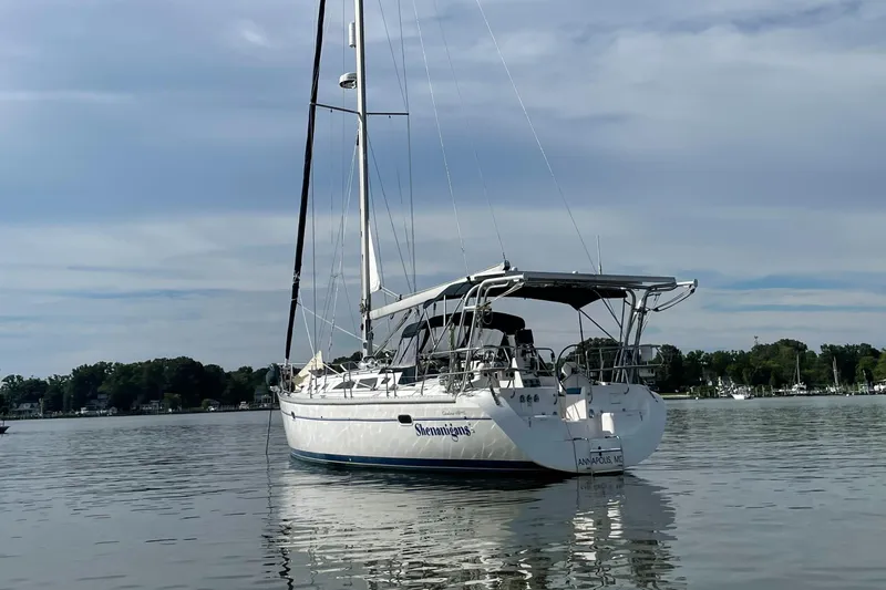 Shenanigans Yacht Photos Pics Catalina 400 MkII sailboat from 2001 anchored on calm water under a cloudy sky.