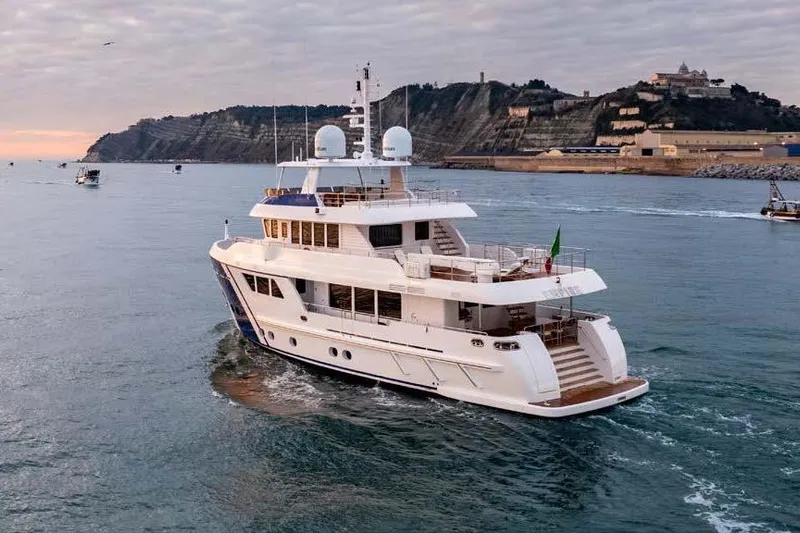 Empire Yacht Photos Pics 2024 Cantiere Delle Marche Darwin 86 yacht cruising near scenic coastline at sunset.