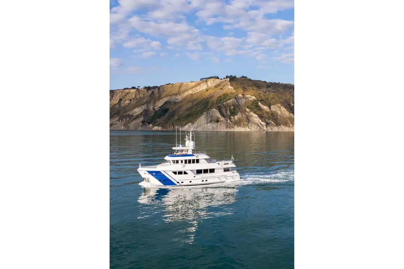 Empire Yacht Photos Pics 2024 Cantiere Delle Marche Darwin 86 yacht cruising near rocky coastline.