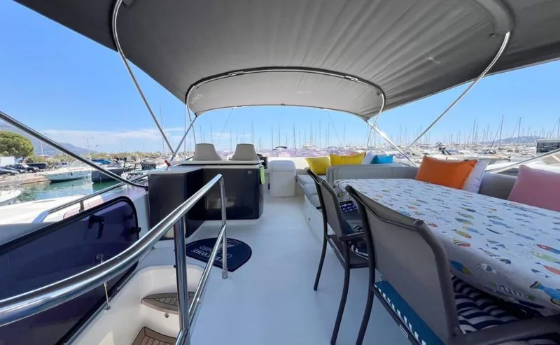  Yacht Photos Pics Luxurious 2016 Princess yacht deck with seating, table, and canopy in a marina setting.