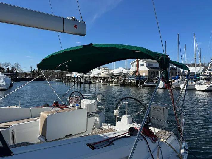 Life Line Yacht Photos Pics 2017 Jeanneau Sun Odyssey 44 DS sailboat docked at marina, featuring green canopy.