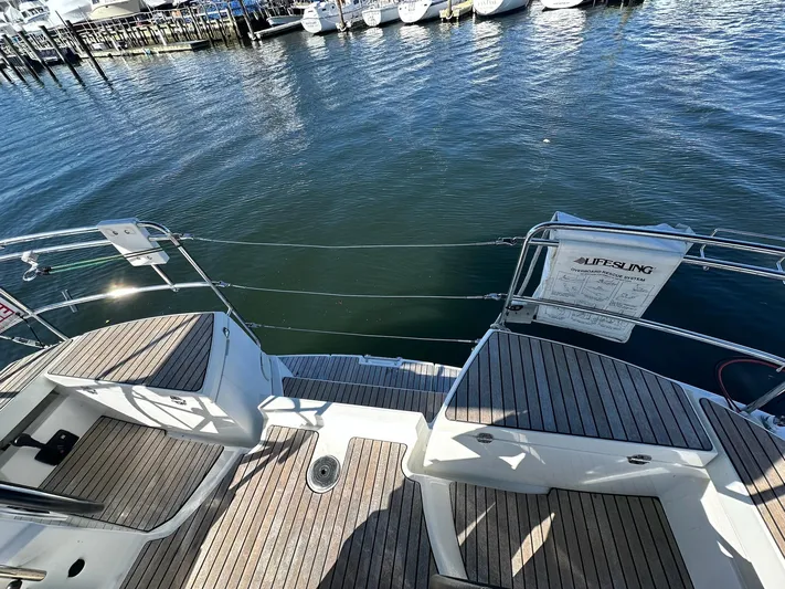 Life Line Yacht Photos Pics Jeanneau Sun Odyssey 44 DS 2017 yacht deck with wooden finish, docked at marina.