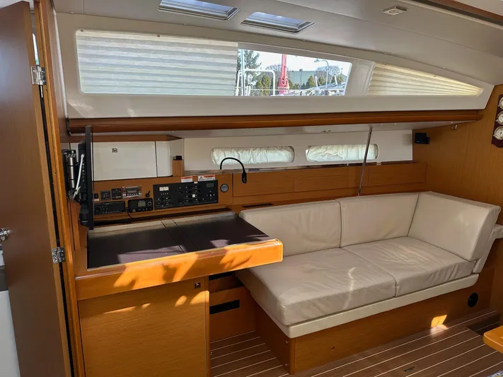 Life Line Yacht Photos Pics Interior of 2017 Jeanneau Sun Odyssey 44 DS yacht with beige seating and navigation station.