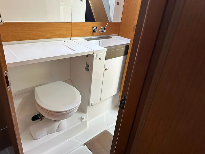 Life Line Yacht Photos Pics Bathroom interior of 2017 Jeanneau Sun Odyssey 44 DS yacht, featuring modern fixtures and wood accents.