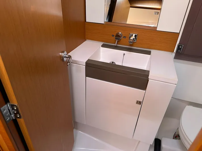 Life Line Yacht Photos Pics Compact bathroom in 2017 Jeanneau Sun Odyssey 44 DS yacht, featuring modern sink and fixtures.