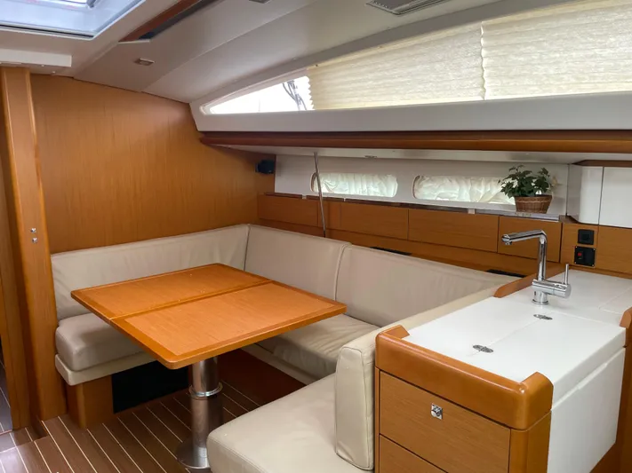 Life Line Yacht Photos Pics Interior of 2017 Jeanneau Sun Odyssey 44 DS yacht with dining area and kitchenette.