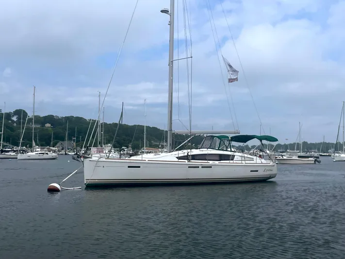 Life Line Yacht Photos Pics 2017 Jeanneau Sun Odyssey 44 DS sailboat anchored in a scenic harbor.