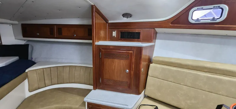 Re-fit 2021-2024 With 2017 Cummins 540s Yacht Photos Pics Interior of 1995 Cabo 35 Express boat with wood cabinetry and seating.