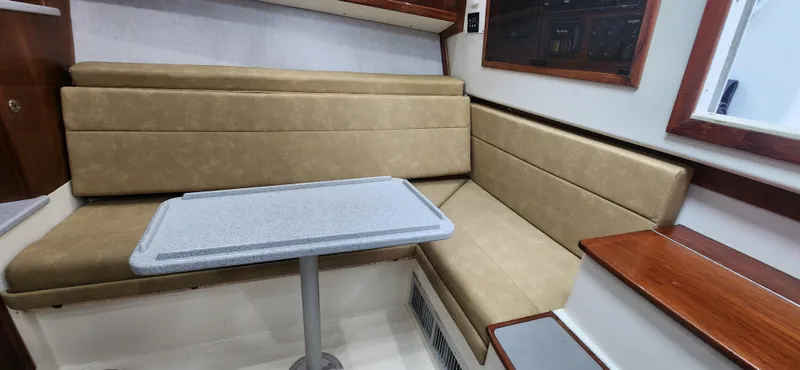 Re-fit 2021-2024 With 2017 Cummins 540s Yacht Photos Pics 1995 Cabo 35 Express interior with beige seating and a small table.