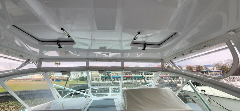 Re-fit 2021-2024 With 2017 Cummins 540s Yacht Photos Pics Interior view of a 1995 Cabo 35 Express boat with marina background.