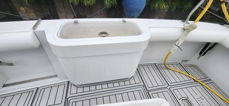 Re-fit 2021-2024 With 2017 Cummins 540s Yacht Photos Pics 1995 Cabo 35 Express boat deck with storage compartment and hose.