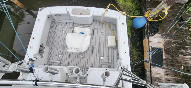 Re-fit 2021-2024 With 2017 Cummins 540s Yacht Photos Pics 1995 Cabo 35 Express boat deck with fishing rod holders and seating, docked near water.