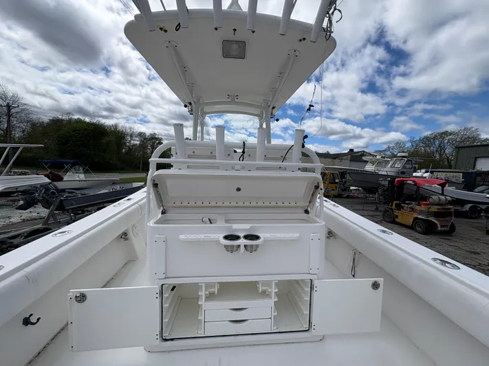  Yacht Photos Pics 2009 Regulator 32 Forward Seating boat with open storage compartments, docked under cloudy skies.