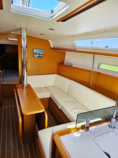 Tharos Yacht Photos Pics Interior of 2016 Jeanneau 379 sailboat with modern wood finish and white seating.
