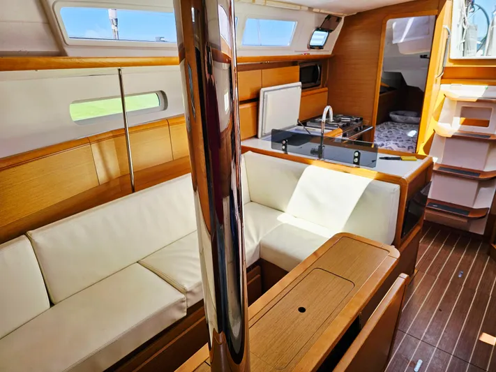 Tharos Yacht Photos Pics Interior of 2016 Jeanneau 379 sailboat with modern wood finish and comfortable seating.