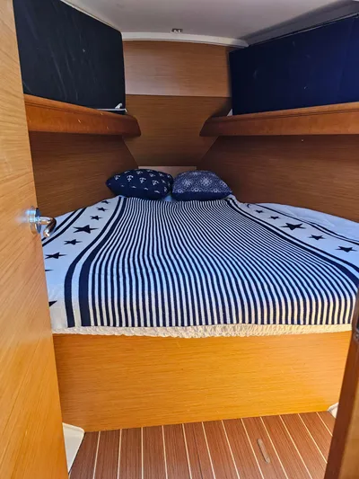 Tharos Yacht Photos Pics Cozy cabin interior of 2016 Jeanneau 379 sailboat with striped bedding.
