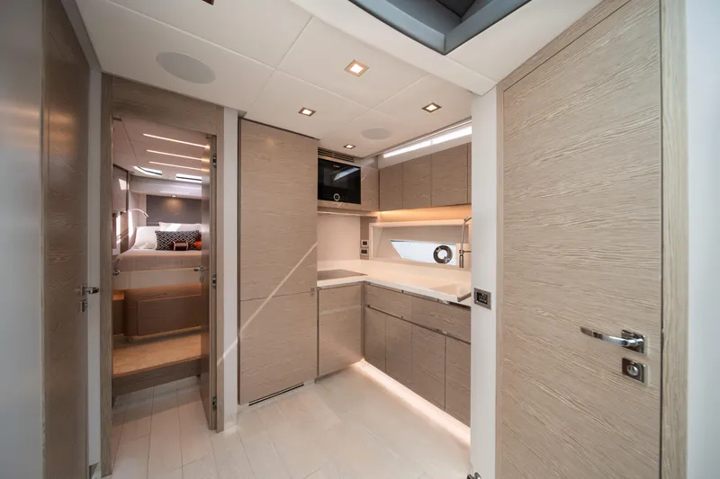 Juice Yacht Photos Pics Luxurious interior of 2019 Filippetti S55 yacht featuring modern kitchen and cozy bedroom.