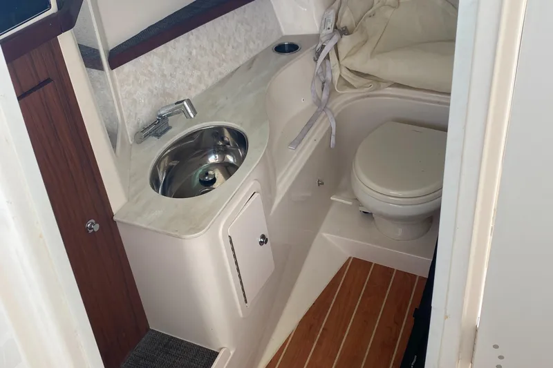  Yacht Photos Pics 2022 Grady-White Freedom 325 boat bathroom with sink, toilet, and wooden flooring.