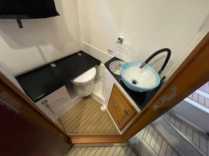  Yacht Photos Pics Compact bathroom in 2024 Victory V400 Open Sea boat with modern sink and toilet.