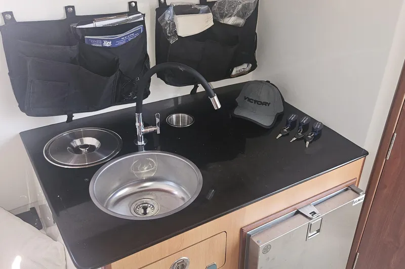  Yacht Photos Pics Compact kitchenette in 2024 Victory Yachts V400 Open Sea, featuring sink, faucet, and storage.