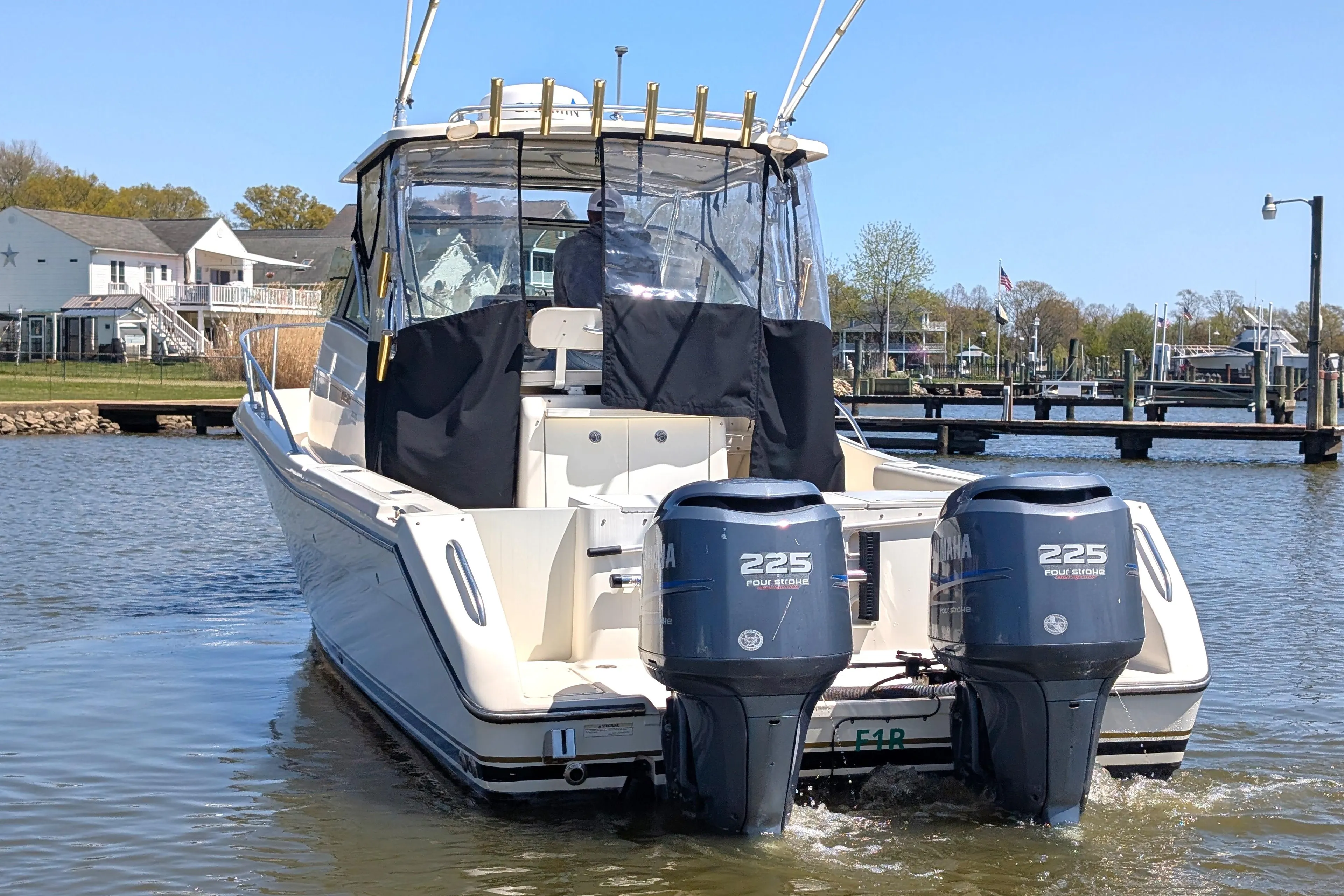 2001 Pursuit 3070 Offshore Center Console boat with twin 225 horsepower engines on a calm waterway.