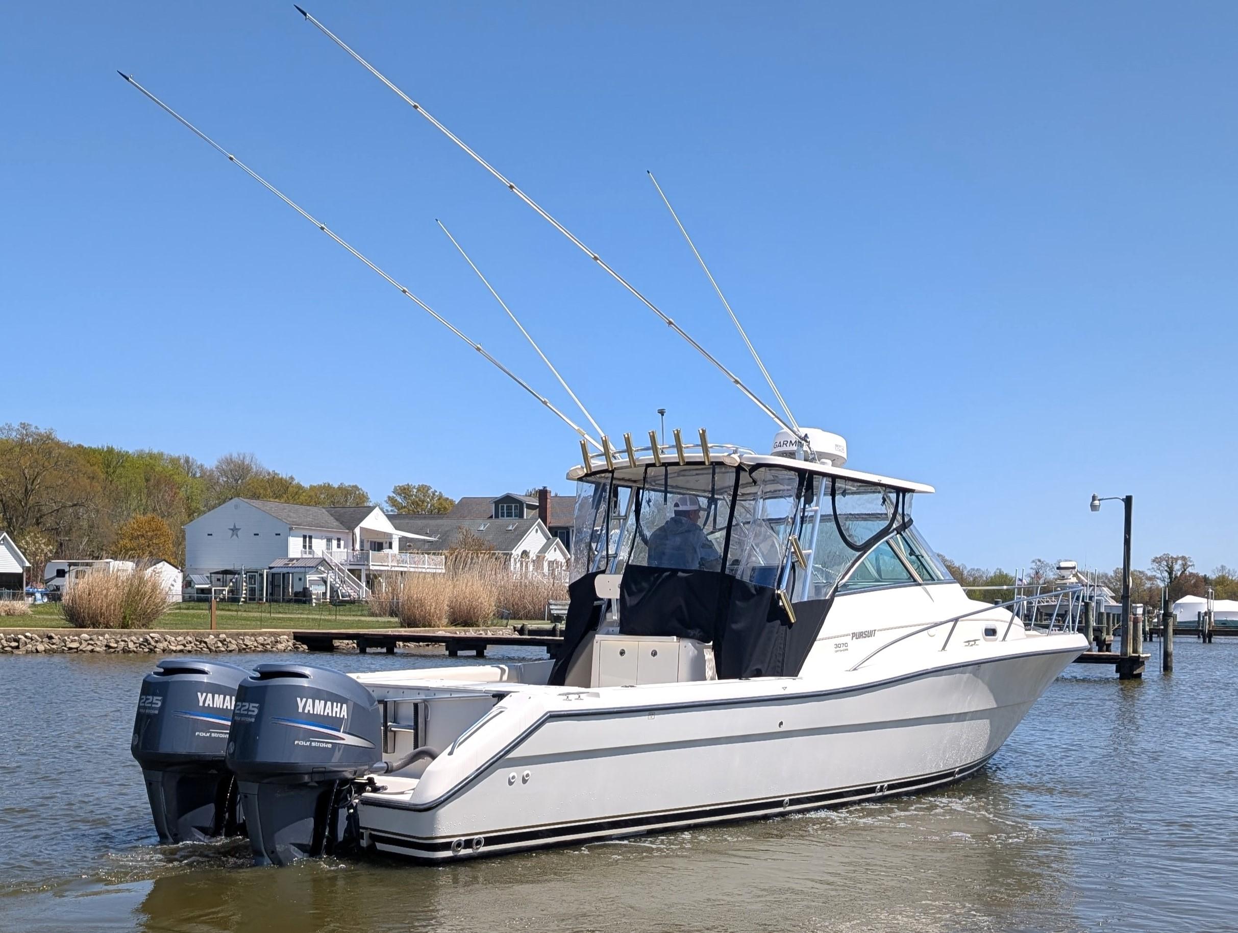 2001 Pursuit 3070 Offshore Center Console boat with dual Yamaha engines on a calm river.
