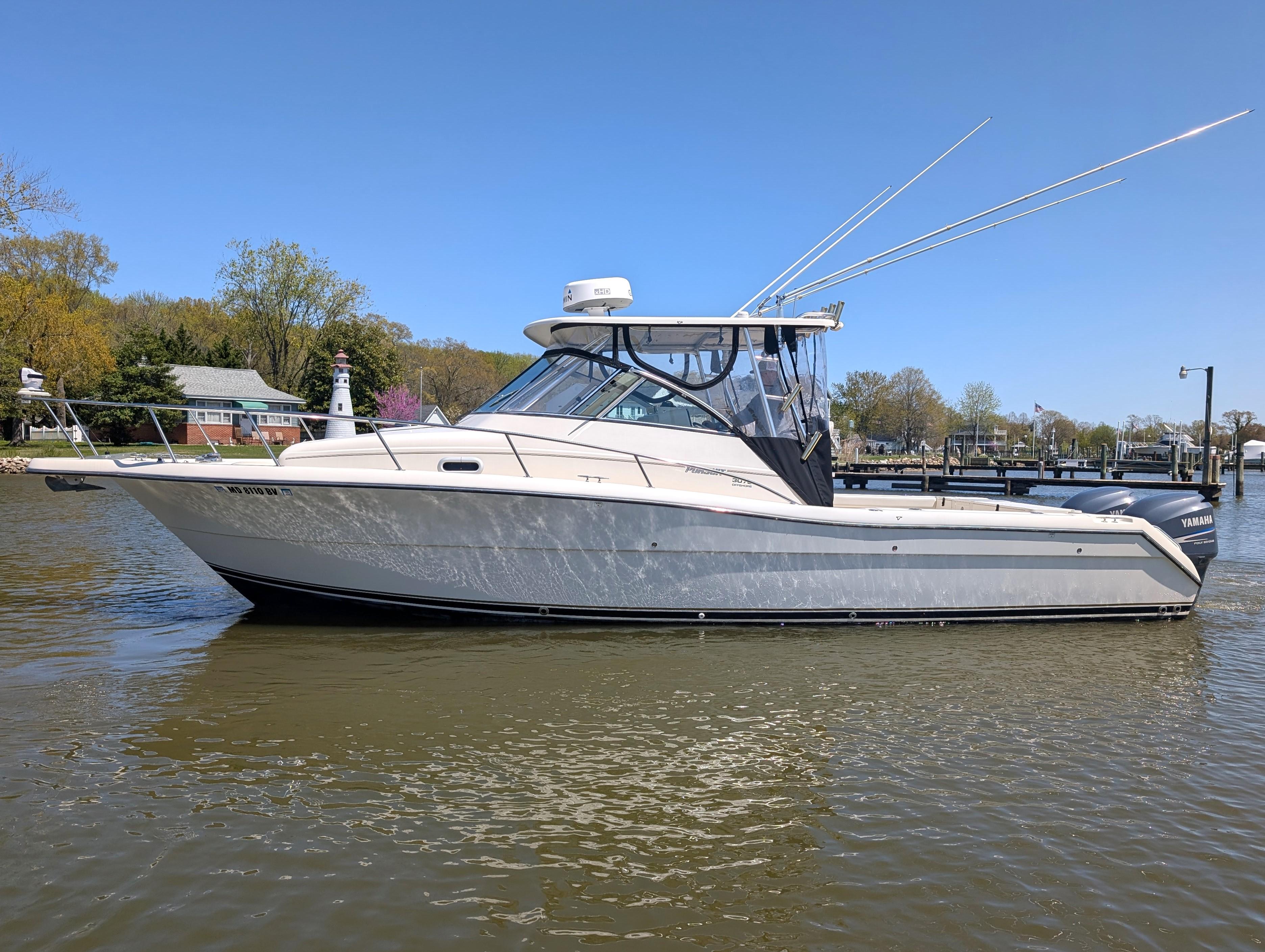 2001 Pursuit 3070 Offshore Center Console boat on calm water, side view.