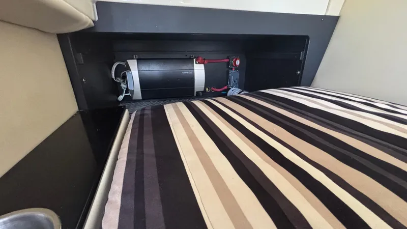  Yacht Photos Pics Interior view of a 2014 Monterey 328 Super Sport boat, featuring a striped cushion and storage compartment.