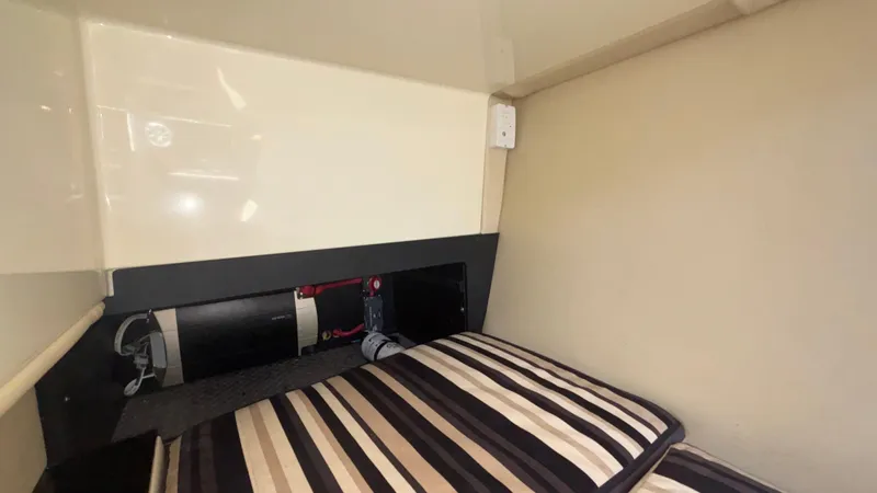  Yacht Photos Pics Interior cabin of 2014 Monterey 328 Super Sport with striped bedding and storage area.