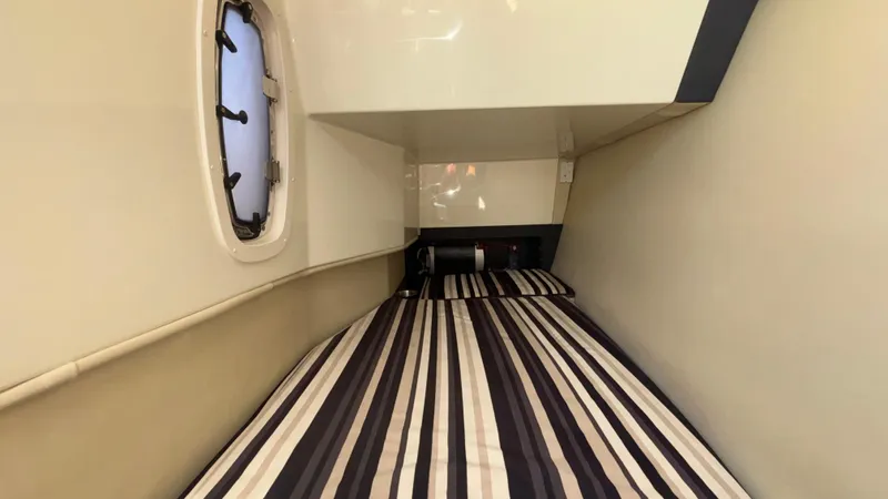  Yacht Photos Pics 2014 Monterey 328 Super Sport cabin interior with striped bedding and porthole window.