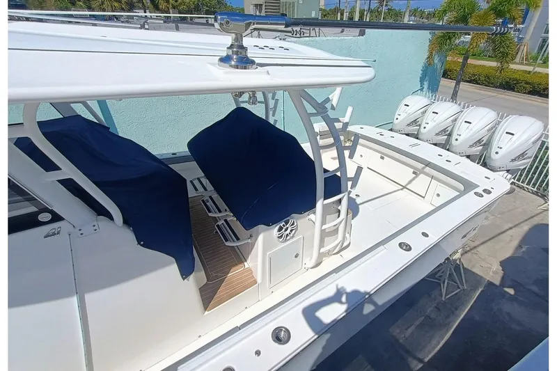 41-083 Yacht Photos Pics 2023 Regulator 41 boat with covered seats and four outboard engines, docked outdoors.