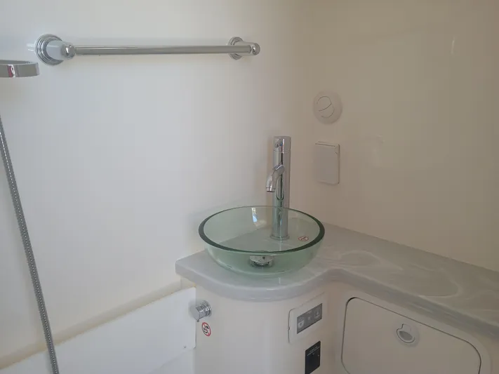 41-083 Yacht Photos Pics Modern bathroom sink in 2023 Regulator 41 boat, featuring glass basin and chrome fixtures.